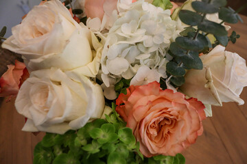 Two stunning bouquets featuring vibrant orange and soft white roses, wrapped in delicate floral paper, perfect for special occasions or thoughtful gifts.