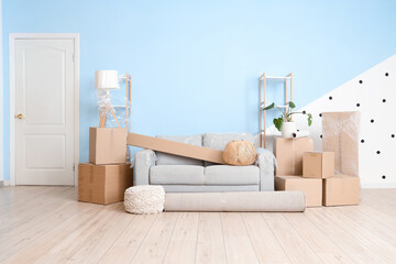Grey sofa with moving boxes in living room