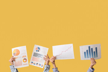 Female hands with diagrams on yellow background. Time management concept