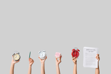 Female hands with alarm clocks, cup and documents on grey background. Time management concept