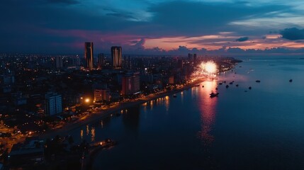 Naklejka premium Aerial view of a city skyline at dusk, illuminated by fireworks over the waterfront.