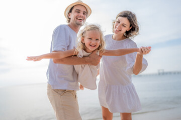 Happy family enjoying vacation on the beach together having fun on summer vacation.