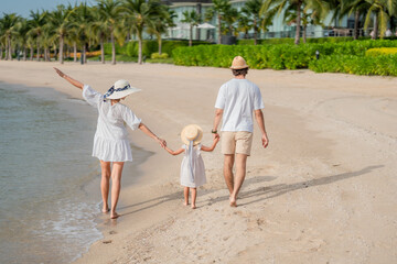 Happy family enjoying vacation on the beach together having fun on summer vacation.