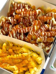 Deep fried chicken wing with garlic sauce in Korean style serve with kimchi and pickled radish in top view on wooden table for asian food concept.
