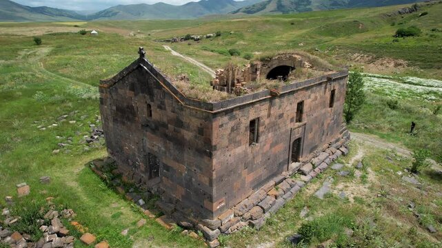 Tilt down aerial footage of Saint Paul and Peter (Surb Pogos Petros) Church on a sunny spring day.  Aparan Reservoir, Armenia.