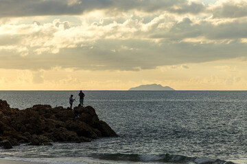 Fishermen fishing from the shore during sunset in Aguadilla, Puerto Rico 