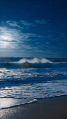 Obraz premium Ocean waves under a starry sky create a serene and mystical atmosphere.