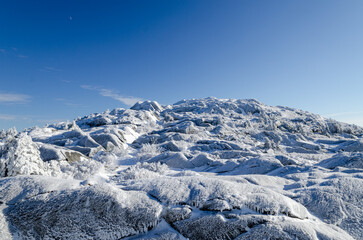 Stunning winter landscape of Mount Monadnock in New Hampshire covered in snow and frost under a clear blue sky