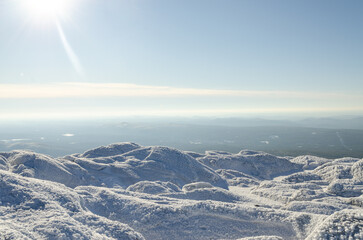 Snow-covered summit of Mount Monadnock in New Hampshire during winter showcases a serene landscape of frost and panoramic views