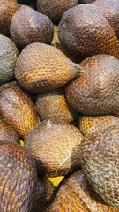 Close up of a pile of snake fruit being sold at the market in the background.