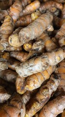Close up pile of tasty fresh turmeric sold at the market as a background.	
