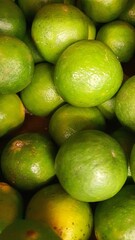 Close up pile of tasty fresh limes sold at the market as a background.