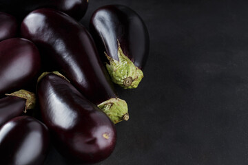 Pile of Freshly Harvested Eggplants on Dark Background, Organic Ecological Food, Copy Space, Top View
