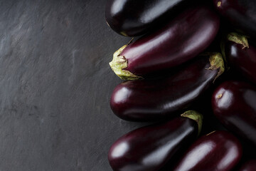 Pile of Freshly Harvested Eggplants on Dark Background, Organic Ecological Food, Copy Space, Top View