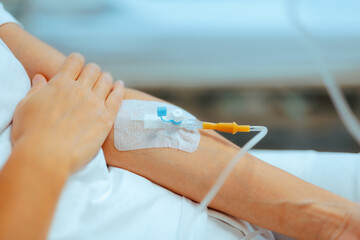 Arm of a Patient with IV Cannula Hospitalized with Dehydration. Person in need of emergency help receiving medication with medical procedure 
