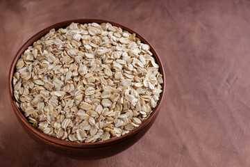 Dry Oat Flakes in Rustic Pottery for Whole Grain Gluten-Free Breakfast and Sustainable Diet, Copy Space