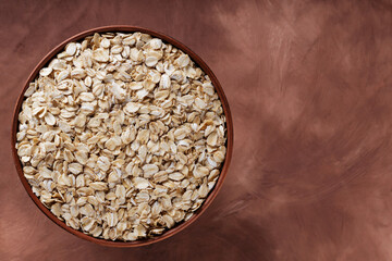 Dry Oat Flakes in Rustic Pottery for Whole Grain Gluten-Free Breakfast and Sustainable Diet, Copy Space