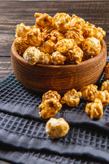 Snack concept, sweet caramelized popcorn in a bowl on a gray, wooden background