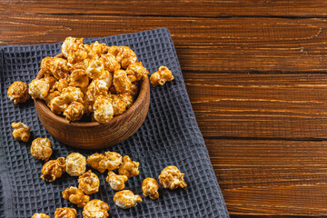 Snack concept, sweet caramelized popcorn in a bowl on a gray, wooden background