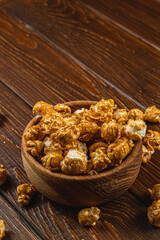 Snack concept, sweet caramelized popcorn in a bowl on a gray, wooden background