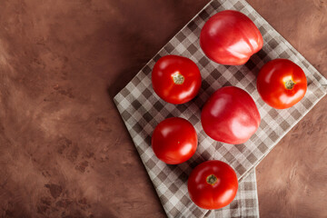 Fresh Red Tomatoes on Beige Checkered Napkin, Brown Background, Copy Space