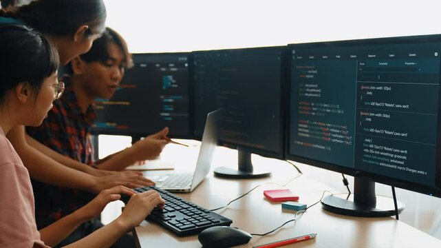 Slow motion back end software developer engineer for computer programming working together on debugging writing computing code, solving complex algorithms display on monitor in office. Burgeoning
