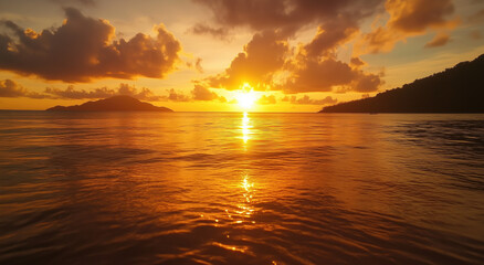 A breathtaking sunset casts warm golden tones over the ocean. Calm waters mirror the sky's vibrant colors, while distant islands enhance the serene landscape during twilight.