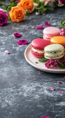 A plate of colorful macarons surrounded by flowers and petals, creating a festive atmosphere.