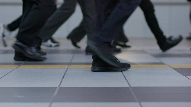 Shoes and feet of people walking in a crowded Tokyo subway train station in slow motion. Captured at 59.94 frames per second.