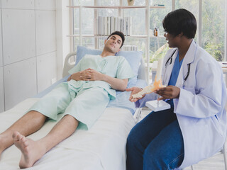 Portrait patient caucasian man with woman doctor nurse carer physical therapist black people two person sitting talk helping support give advice and holding relax check on leg body inside hospital