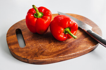 fresh red bell peppers on wooden chopping board, simple natural healthy ingredients