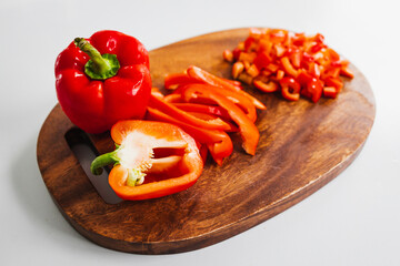 fresh red bell peppers on wooden chopping board, simple natural healthy ingredients