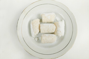 White rice cakes are neatly arranged on a plate on the table