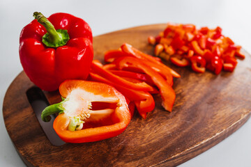 fresh red bell peppers on wooden chopping board, simple natural healthy ingredients