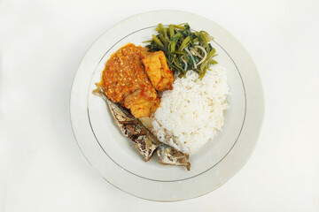 Rice mixed with fried fish and tempeh vegetables on a white plate, on the table