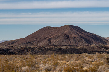Fototapeta premium Cinder Cone / Scoria Cone with Lava Flow. Cima volcanic field. Kelbaker Road, Mojave National Preserve. San Bernardino County, California. Mojave Desert / Basin and Range Province.