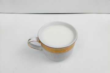 White milk in a white glass on a white table