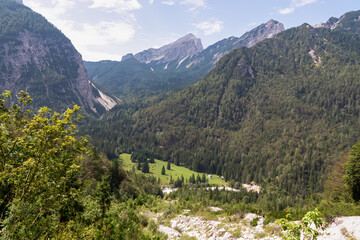 Scenic view kacji graben valley covered with coniferious forest and surrounded by rugged mountain...