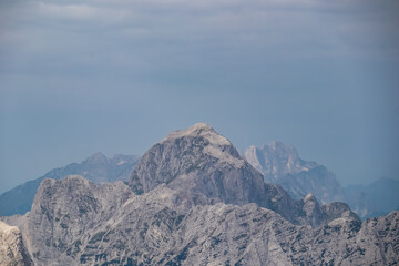 Panoramic view of rugged mountain ridge Mangart in majestic Julian Alps seen from top of summit...