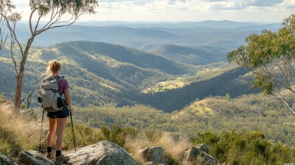 Naklejka premium Woman hiking with backpack, panoramic mountain vista.