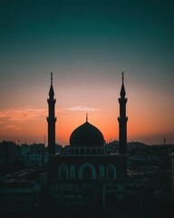 Fototapeta premium Majestic Mosque Silhouette at Sunset: A Breathtaking View of Islamic Architecture against the Orange Sky