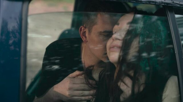 A couple enjoys a tender moment together in a vehicle, surrounded by nature's beauty. Their closeness and warmth create a romantic atmosphere filled with love and connection.