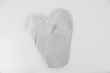 One time use hotel slippers on a white