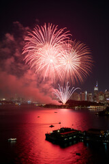 Spectacular Red Fireworks Illuminating City Skyline Over Reflective Water