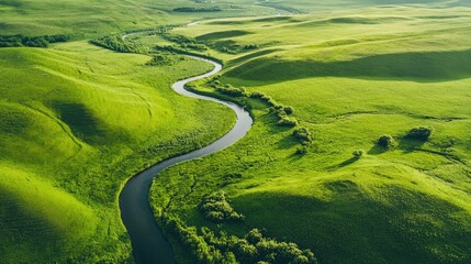 Aerial view of a meandering river flowing through lush green hills and valleys.