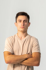 Fototapeta premium Young confident man in T-shirt close-up on a white background, copy space