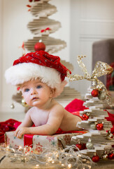 little child in santa hat with christmas tree
