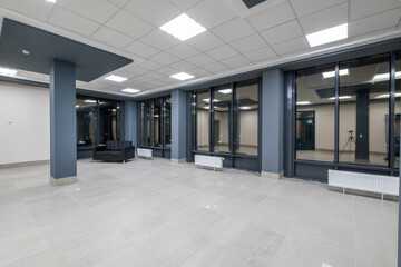 panorama view in empty modern hall with columns, doors and panoramic windows at night