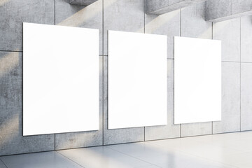 Three blank vertical white posters on a grey concrete wall with sunlight and shadows, perfect for mockup or advertising display. 3D Rendering