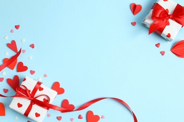 Gift boxes with red hearts on color background